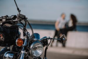 selective focus of vintage classical motorbike with couple on background