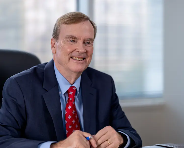 Picture of smiling Jim Hurley in a suit and tie