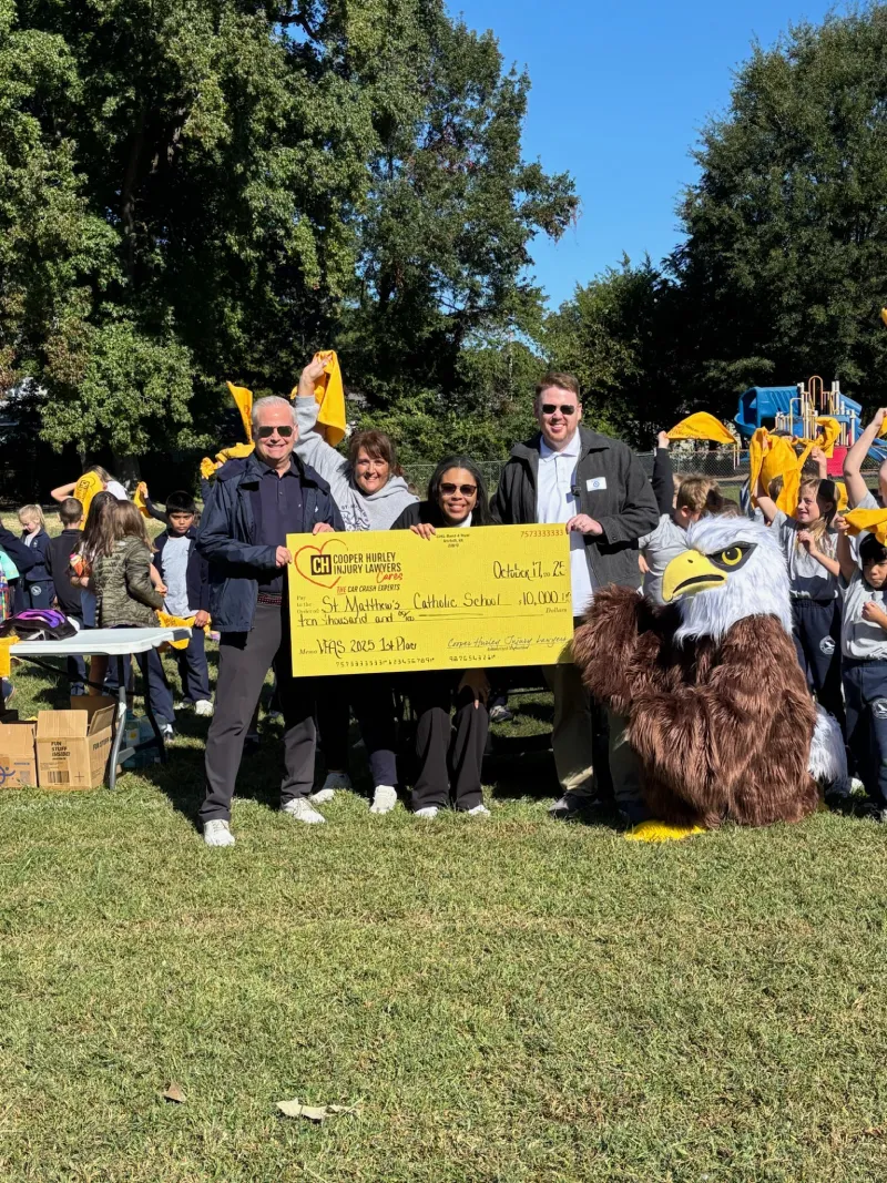 Cooper Hurley Injury Lawyers presents a $10,000 check to St. Matthews Catholic School.